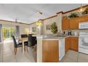 Kitchen with light wood cabinets, white appliances, and a breakfast bar at 4765 Ormond Beach Way, Kissimmee, FL 34746