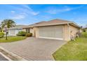 House exterior featuring a large garage and brick paver driveway at 490 Sweetwater Way, Haines City, FL 33844