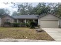 One-story house with attached garage and manicured lawn at 5022 Log Wagon Rd, Ocoee, FL 34761