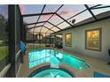 Screened pool and spa with seating area at sunset at 745 Andrew St, Eustis, FL 32726