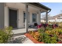 Covered front porch with seating and colorful landscaping at 9118 Waverly Walk Dr, Orlando, FL 32817