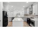 Modern kitchen with white cabinets, quartz countertops, and stainless steel appliances at 11833 Founders St, Orlando, FL 32832