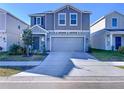 Two-story house with gray siding, attached garage, and landscaping at 1534 Marksman Rd, Eagle Lake, FL 33839