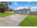 Newly remodeled home with gray exterior, green lawn, and long driveway at 3662 Mohawk Dr, Mount Dora, FL 32757