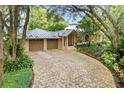 Brick driveway leading to a two-car garage with lush landscaping at 451 Northwind Rd, Maitland, FL 32751