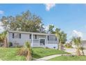 Gray house with white garage door, landscaping, and palm trees at 4862 Indialantic Dr, Orlando, FL 32808