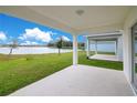 Covered patio overlooking a lake with lush green grass at 5302 Royal Point Ave, Kissimmee, FL 34746