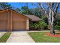 Charming home featuring a two-car garage, well-maintained lawn, and mature landscaping at 596 Albany Pl, Longwood, FL 32779