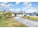 House exterior showcasing a light green color, metal roof, and a long driveway at 628 Twin Oaks Cir, Daytona Beach, FL 32117