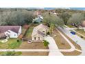 Aerial view of a single-story home featuring mature landscaping, spacious driveway, and lush trees at 905 Hatteras Ave, Minneola, FL 34715