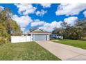 Nice curb appeal, featuring a gray garage and red front door at 4089 Sw 133Rd Loop, Ocala, FL 34473