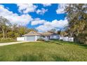 Charming one-story home with a red front door and green lawn at 4089 Sw 133Rd Loop, Ocala, FL 34473