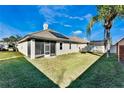 Spacious backyard with green lawn, partially covered patio, and plenty of room to relax at 10812 Woodchase Cir, Orlando, FL 32836