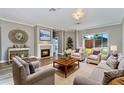 Bright living room with plush furniture, fireplace, and large window showcasing backyard at 10812 Woodchase Cir, Orlando, FL 32836