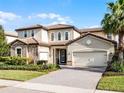 Charming two-story home with a stone facade, red tile roof, paver driveway, and manicured landscaping at 10875 Savona Way, Orlando, FL 32827