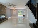 Open concept living room featuring modern lighting, glossy tile floors, and a stone fireplace accent wall at 13124 Oulton Cir, Orlando, FL 32832