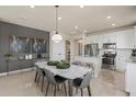 Modern kitchen with white cabinets, marble top island, and stainless steel appliances at 13563 Pearl Beach St, Winter Garden, FL 34787