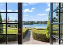 Open french doors showcase a breathtaking lake view from inside the home at 1522 Lake Knowles Cir, Winter Park, FL 32789