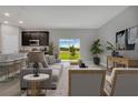 Living room with view of backyard, gray couch, and kitchen with island at 1720 Columbus Path, St Cloud, FL 34771