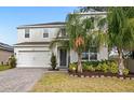 Two-story house with white exterior, landscaping, and palm trees at 2041 Brillante Dr, St Cloud, FL 34771