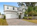 Two-story house with a white exterior, paved driveway, and landscaping at 2041 Brillante Dr, St Cloud, FL 34771