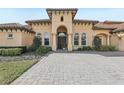 Stunning home exterior featuring an arched entryway, tiled roof, well-maintained landscaping, and a stone paver driveway at 3764 Farm Bell Pl, Lake Mary, FL 32746