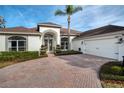 White house with a brick driveway, two-car garage, and palm trees at 3788 Brantley Place Cir, Apopka, FL 32703