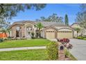 Two-story house with a three-car garage and a well-maintained lawn at 3838 Gatlin Place Cir, Orlando, FL 32812