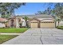 Large brick home with a three-car garage and spacious driveway at 3838 Gatlin Place Cir, Orlando, FL 32812