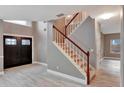 Two-story home with an entryway featuring a staircase, dark double doors, and gray walls at 601 Kelly Green St, Oviedo, FL 32765