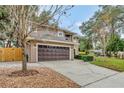 Two-story house with driveway, landscaping, and wooden fence at 601 Kelly Green St, Oviedo, FL 32765