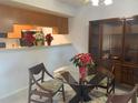 Dining room features a glass top table with three chairs and a built in wood china cabinet at 6073 Windhover Dr # C04, Orlando, FL 32819