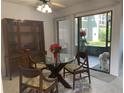 Dining area with glass table and four chairs, adjacent to kitchen at 6073 Windhover Dr # C04, Orlando, FL 32819