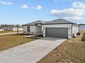 Newly built home with gray garage door and landscaped lawn at 803 Fraser Dr, Poinciana, FL 34759