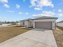 Newly built home with gray garage door and landscaped lawn at 803 Fraser Dr, Poinciana, FL 34759