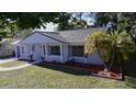 Newly renovated home with gray exterior, landscaping, and a paved walkway at 10118 Allenby Ct, Orlando, FL 32821