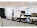 Modern kitchen with white cabinets, granite countertops, and a large island at 10118 Allenby Ct, Orlando, FL 32821