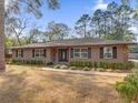 Tan house with stone accents, landscaping, and a spacious lawn at 126 Se 41St Ave, Ocala, FL 34471
