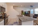 Open concept kitchen with granite island, stainless steel appliances and breakfast bar at 2229 Shadowland Loop, Winter Park, FL 32792