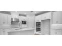 Bright kitchen featuring white cabinetry, stainless steel appliances, and a functional island with a modern faucet at 2983 Arranmore Dr, Ormond Beach, FL 32174