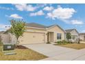 Inviting single-Gathering home featuring a two-car garage, tidy landscaping, and a welcoming entrance at 5581 Tranquila Ln, Davenport, FL 33897