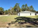 Side view of a newly built light green house with grassy yard at 6365 Sw 156 Th St St, Ocala, FL 34473