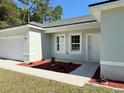 Front entrance of a newly built light green house with walkway at 6365 Sw 156 Th St St, Ocala, FL 34473