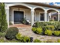 Inviting front porch with brick flooring, wicker chairs, and lush greenery at 815 E Pine St, Orlando, FL 32801