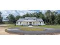 White farmhouse with gray roof, circular driveway, and large yard at 10750 Sw 110Th St, Dunnellon, FL 34432