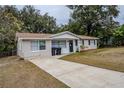 Tan house with brown roof and a driveway at 5511 Indian Hill Rd, Orlando, FL 32808