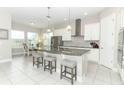 Bright kitchen with stainless steel appliances, granite countertops, island seating, and an adjacent dining area at 618 Windy Pine Way, Oviedo, FL 32765