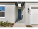 Modern front door with gray color and sleek hardware at 8549 Sw 129Th Ln, Ocala, FL 34473