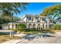 Two-story house with a balcony, arched entryway, and manicured lawn at 1000 Via Tuscany Oaks Way, Winter Park, FL 32789