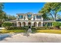 Two-story house with a balcony, arched entryway, and manicured lawn at 1000 Via Tuscany Oaks Way, Winter Park, FL 32789